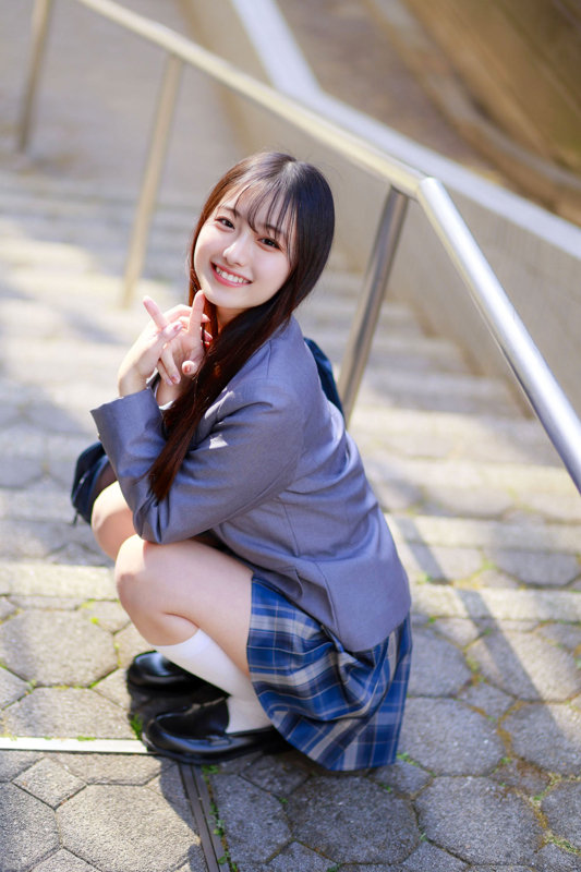 制服風ブレザー姿で石畳の階段にしゃがみ、ニーハイソックスを合わせてカメラに微笑みかける女性のサンプル画像